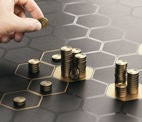 A hand moving coins around a hexagon game board