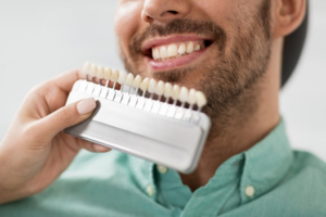 Dentist comparing veneers to a patient’s natural teeth